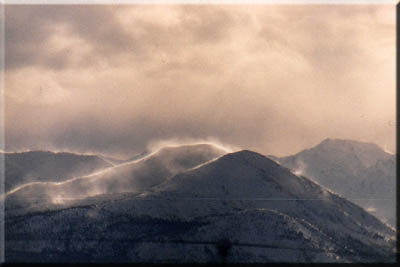 Winter wind sweeping snow from a mountain.