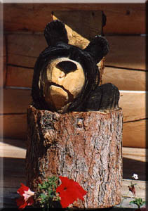 A chainsaw-carved wooden bear on the cabin porch.