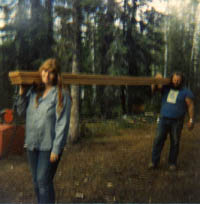 Dick and Donna shouldering logs and lumber.